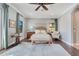 Comfortable main bedroom with a ceiling fan, wood floors, and large windows for ample natural light at 8197 Via Vittoria Way, Orlando, FL 32819