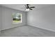 Spacious bedroom with gray carpet, ceiling fan, and large window at 849 Jarnac Dr, Kissimmee, FL 34759