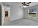 Bedroom with gray carpet, ceiling fan, and view of kitchen at 849 Jarnac Dr, Kissimmee, FL 34759
