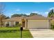 Beige house with a two-car garage and a well-manicured lawn at 849 Jarnac Dr, Kissimmee, FL 34759