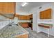 Kitchen with wood cabinets, granite counters, and tile floor at 849 Jarnac Dr, Kissimmee, FL 34759