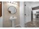 Small powder room with pedestal sink and modern mirror at 1041 Las Fuentes Dr, Kissimmee, FL 34746