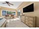 Bright main bedroom with a large TV and access to the pool at 1519 Lake Rhea Dr, Windermere, FL 34786