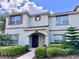 Two-story townhome with light-colored siding, brown accents, and landscaping at 1582 Moon Valley Dr, Champions Gate, FL 33896
