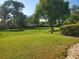 Large grassy yard with mature trees and a partially visible house in the background at 1902 Abbington St # 1902, Apopka, FL 32712