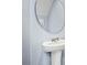 Small powder room with pedestal sink and round mirror at 1960 Tamarack Pass, Davenport, FL 33837