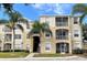 Building exterior featuring a multi-story residential building with balconies and palm trees at 2302 Butterfly Palm Way # 102, Kissimmee, FL 34747
