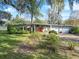 Mid-century modern home with a two-car garage and landscaped lawn at 3644 Lake Shore Dr, Apopka, FL 32703