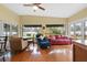 Sunlit Gathering room boasts hardwood floors, a red leather couch, and serene water views at 3644 Lake Shore Dr, Apopka, FL 32703