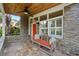 Relaxing covered porch with stonework and wooden bench at 3644 Lake Shore Dr, Apopka, FL 32703