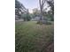 Large backyard with unkempt grass and mature trees at 4419 Lake Lawne Ave, Orlando, FL 32808
