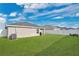 Grassy backyard with full white fence and view of the house with blue skies and white clouds at 4505 Hummingbird Ln, Haines City, FL 33844