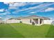 Wide grassy backyard featuring full white fence with view of the house and blue skies at 4505 Hummingbird Ln, Haines City, FL 33844