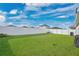 Large backyard with full white fence and lush green grass with blue skies and white clouds at 4505 Hummingbird Ln, Haines City, FL 33844