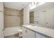 Tiled bathroom with tub and shower features neutral color scheme with stone countertop and modern fixtures at 4505 Hummingbird Ln, Haines City, FL 33844