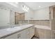 Elegant bathroom with double vanity, soaking tub, and tiled shower, complemented by neutral color tones at 4505 Hummingbird Ln, Haines City, FL 33844