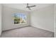 Serene bedroom featuring neutral carpet, ample natural light from the large window, and ceiling fan at 4505 Hummingbird Ln, Haines City, FL 33844