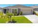 Single-story house with gray siding, two-car garage, and landscaping at 4505 Hummingbird Ln, Haines City, FL 33844