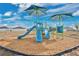 Community playground with multiple slides, climbing structures, and sun shades on a wood chip surface at 4505 Hummingbird Ln, Haines City, FL 33844