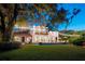 House with string lights, lush lawn, and nighttime view at 541 Virginia Dr, Winter Park, FL 32789