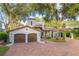 Stunning Spanish-style home with a brick driveway and lush landscaping at 541 Virginia Dr, Winter Park, FL 32789