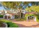 Beautiful Spanish-style home with a large tree and brick driveway at 541 Virginia Dr, Winter Park, FL 32789