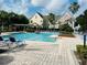 Resort style pool surrounded by lounge chairs, palm trees, and lush landscaping at 6413 Astor Village Ave # 314, Orlando, FL 32835