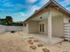Private backyard patio adjacent to house with sand and stone path at 821 E 1St Ave, New Smyrna Beach, FL 32169