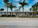 A light beige home with white trim and a large front yard, under a bright sky at 821 E 1St Ave, New Smyrna Beach, FL 32169