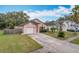 Cute pink house with a two-car garage and well-maintained lawn at 9606 Chandon Dr, Orlando, FL 32825