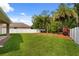 Spacious backyard with well-maintained lawn, mature trees, and white fencing, offering privacy at 10097 Leland Dr, Orlando, FL 32827