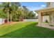 Landscaped backyard with lush green grass, palm trees, and a privacy fence, perfect for outdoor living at 10097 Leland Dr, Orlando, FL 32827