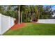 A beautifully landscaped backyard with lush greenery, mulch beds, and tall palm trees at 10097 Leland Dr, Orlando, FL 32827