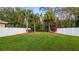Well-maintained backyard with vibrant greenery, palm trees, and a secure white fence at 10097 Leland Dr, Orlando, FL 32827
