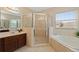Bright bathroom with a glass shower, soaking tub, and tile flooring at 10097 Leland Dr, Orlando, FL 32827