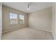 Neutral bedroom with carpet, ceiling fan and natural light filtering in through the two windows at 10097 Leland Dr, Orlando, FL 32827