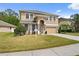 Charming two-story home featuring stone accents, a well-manicured lawn, and a welcoming front entrance at 10097 Leland Dr, Orlando, FL 32827