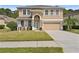 Charming two-story home featuring stone accents, a well-manicured lawn, and a welcoming front entrance at 10097 Leland Dr, Orlando, FL 32827