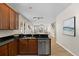 Kitchen featuring dark wood cabinets, black counters, stainless steel dishwasher and open to the living area at 10097 Leland Dr, Orlando, FL 32827