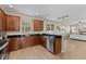 Charming kitchen featuring wood cabinets, black countertops, stainless steel appliances and wood-look flooring at 10097 Leland Dr, Orlando, FL 32827