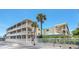 Two-story building exterior with balconies and palm trees at 111 N Atlantic Ave # 2090, New Smyrna Beach, FL 32169