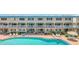 Community pool and patio area with lounge chairs and tables at 111 N Atlantic Ave # 2090, New Smyrna Beach, FL 32169