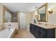 Main bathroom with soaking tub, shower, and dark vanity at 11944 Cheltinham Dr, Orlando, FL 32824