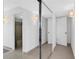 Hallway with mirrored closet doors and bathroom access at 1420 N Atlantic Ave # 1501, Daytona Beach, FL 32118