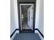 An open white front door leads into a bright, freshly painted interior with hardwood flooring at 1608 Airmont Ave, Deltona, FL 32725