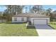White house with gray roof, two-car garage, and a well-manicured lawn at 1608 Airmont Ave, Deltona, FL 32725