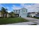 Two-story light blue house with a two-car garage and landscaped lawn at 1706 Chatsworth Cir, Saint Cloud, FL 34771