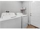 Bright laundry room with washer, dryer, and storage shelf at 1780 Sw 168Th Loop, Ocala, FL 34473