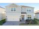 Charming two-story home with two-car garage, beautiful lawn and modern design elements, enhancing curb appeal at 1914 Summer Serenity Dr, Kissimmee, FL 34744