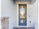 Modern gray front door with glass panels and stone accents at 1914 Summer Serenity Dr, Kissimmee, FL 34744